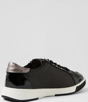Black sneaker with white sole on a light gray background