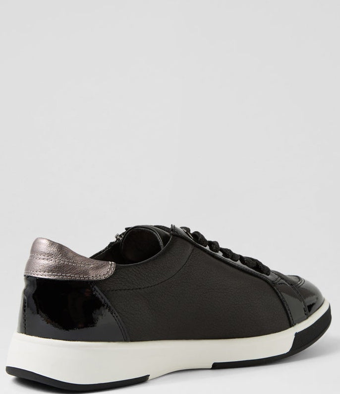 Black sneaker with white sole on a light gray background
