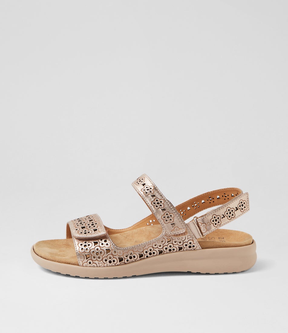 Rose gold sandal with decorative straps on a light gray background