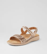 Beige sandal with floral cut-out design on a light gray background