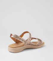Beige sandal with cut-out design on a light gray background.