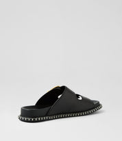 Ziera Iyami sandal in black leather with adjustable straps, brass accents, and supportive low-profile sole on a white background