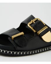 Ziera Iyami sandal in black leather with adjustable straps, brass accents, and supportive low-profile sole on a white background